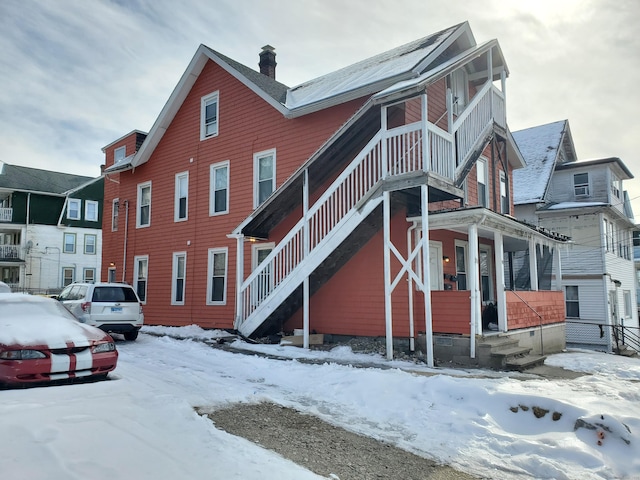 view of snow covered exterior featuring a chimney