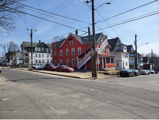 view of road featuring a residential view, curbs, street lighting, and sidewalks