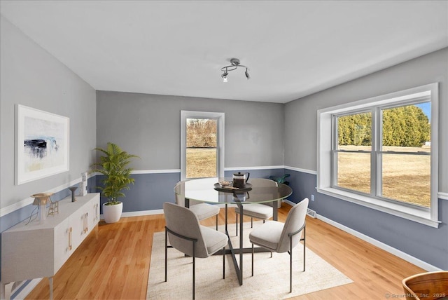 dining room with light wood-style floors and baseboards