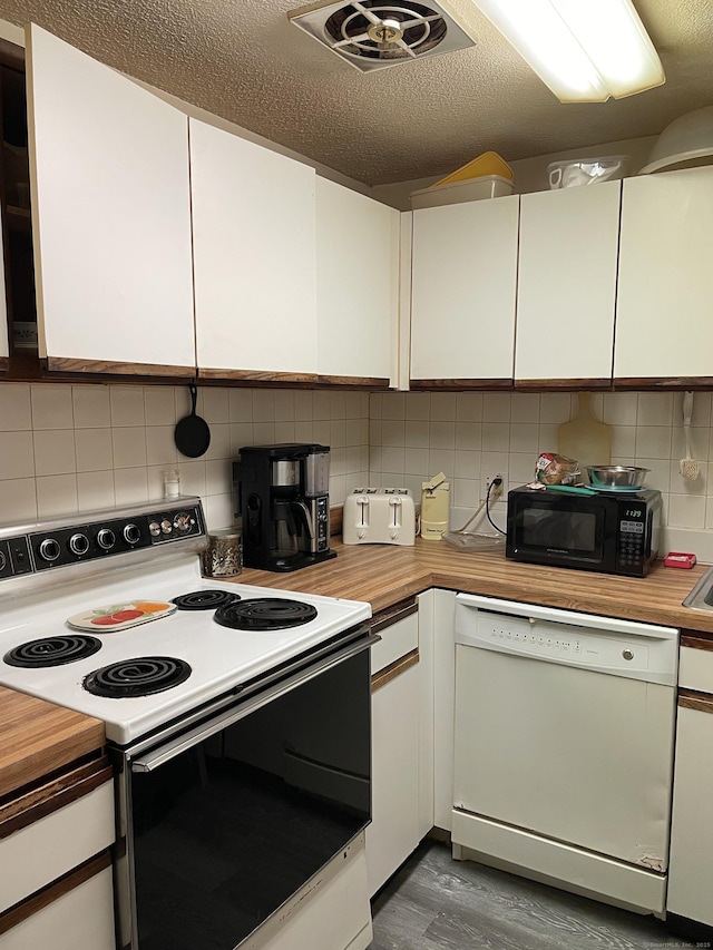 kitchen with black microwave, white dishwasher, white cabinets, electric stove, and backsplash