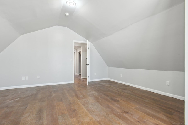 additional living space featuring lofted ceiling, baseboards, and wood finished floors