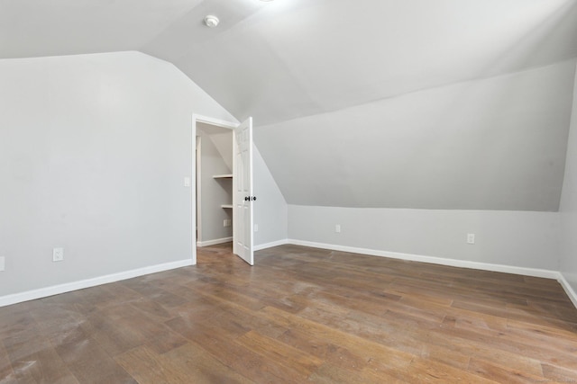 bonus room with lofted ceiling, baseboards, and dark wood finished floors