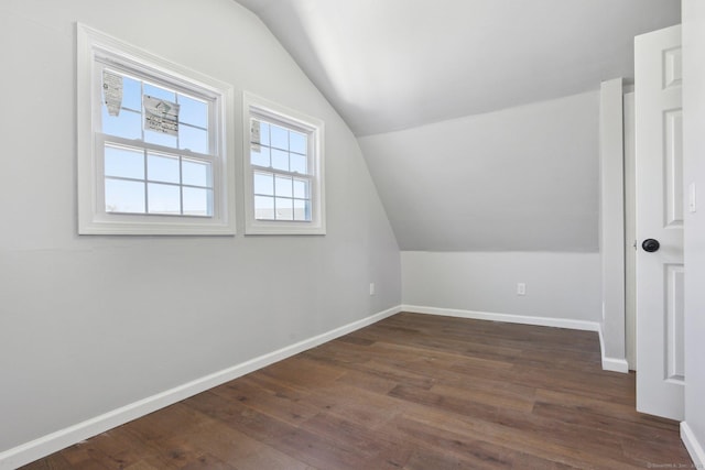 bonus room featuring vaulted ceiling, dark wood finished floors, and baseboards