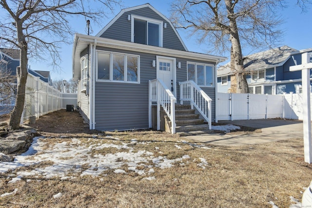 view of front of home with fence, central AC, and a gambrel roof