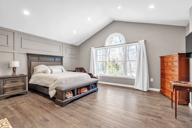 bedroom with light wood-style floors, lofted ceiling, baseboards, and recessed lighting