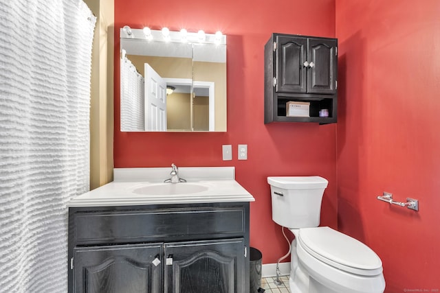 full bathroom with toilet, vanity, and baseboards