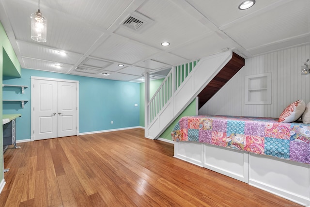 living room featuring baseboards, visible vents, stairway, and wood finished floors