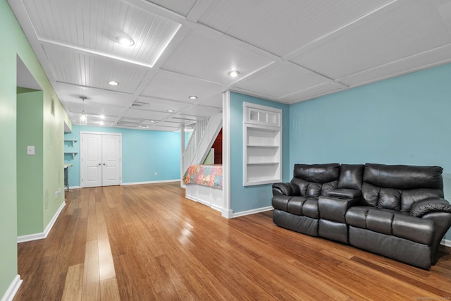 living room with baseboards, built in features, and wood finished floors