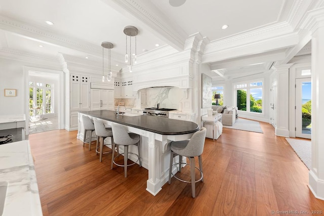 260 Hillspoint Rd, Westport, CT 06880 - kitchen featuring wood finished floors, white cabinetry, open floor plan, hanging light fixtures, and decorative columns