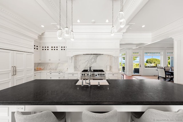 260 Hillspoint Rd, Westport, CT 06880 - kitchen with white cabinetry, backsplash, a large island with sink, and ornamental molding