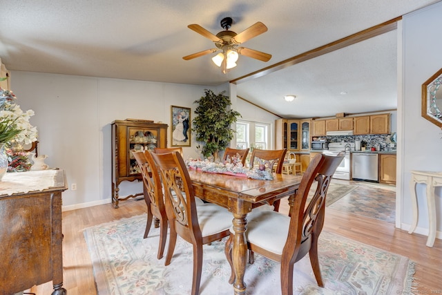 dining room with vaulted ceiling with beams, light wood finished floors, a ceiling fan, and a textured ceiling