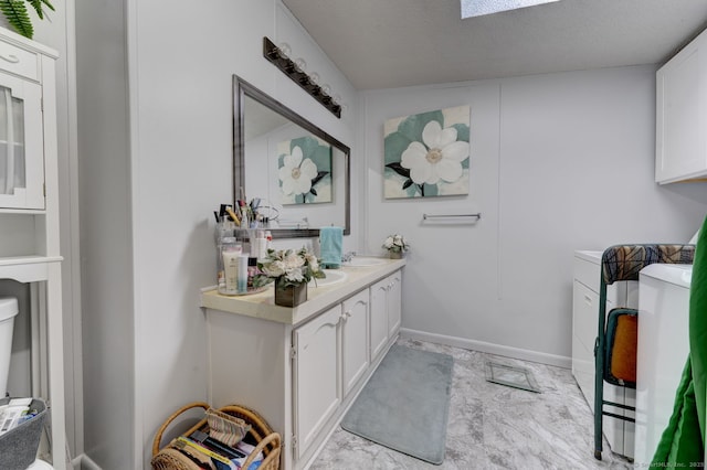 bathroom featuring baseboards, a textured ceiling, and vanity