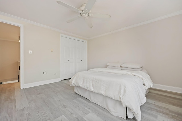 bedroom featuring light wood finished floors, baseboards, ceiling fan, ornamental molding, and a closet