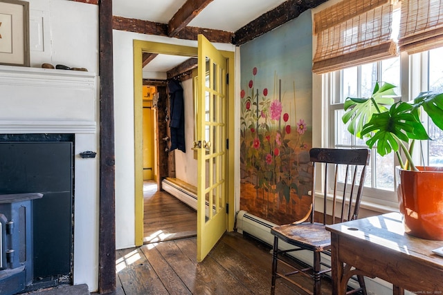 interior space with wood-type flooring, beamed ceiling, baseboard heating, and a wealth of natural light