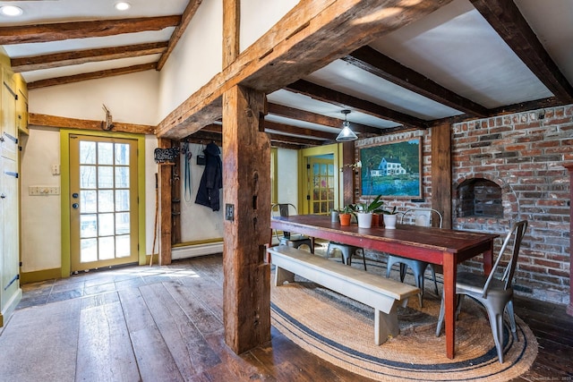 dining room featuring lofted ceiling with beams, wood-type flooring, and baseboards