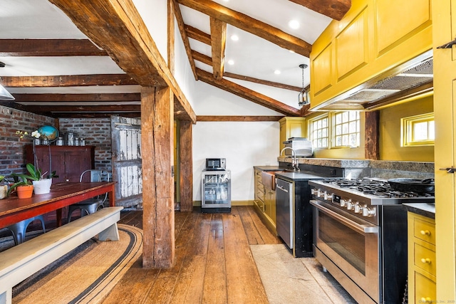 kitchen featuring dark countertops, brick wall, wood-type flooring, stainless steel appliances, and beam ceiling