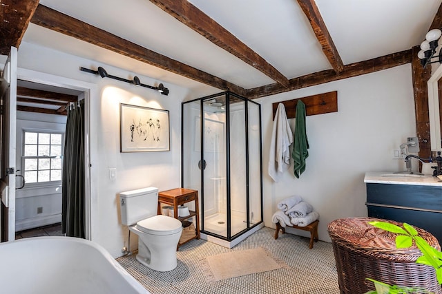 bathroom featuring beamed ceiling, a shower stall, toilet, vanity, and a soaking tub