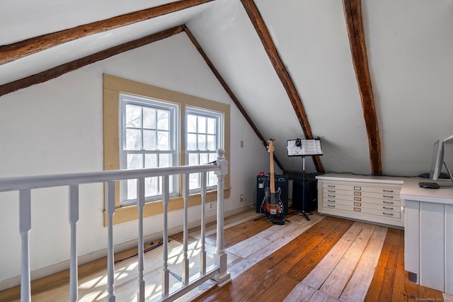 bonus room featuring light wood finished floors and vaulted ceiling with beams