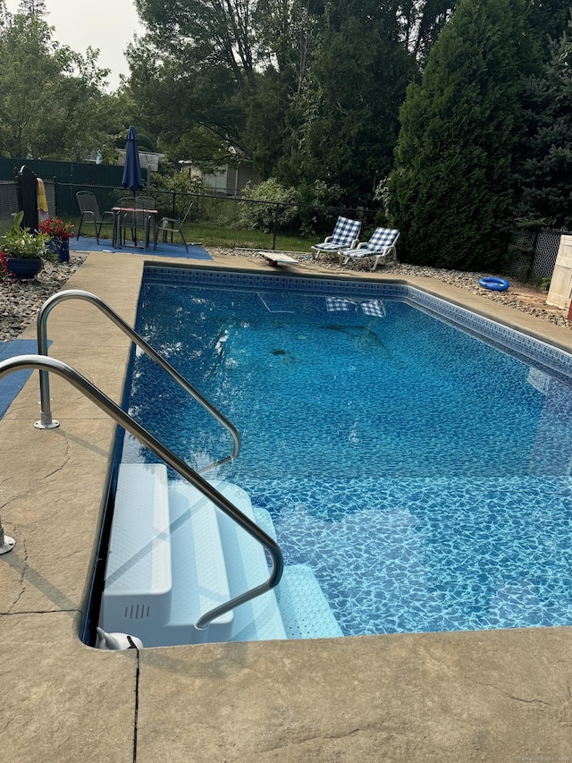 view of swimming pool featuring a patio area, a fenced in pool, and fence