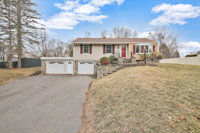 single story home featuring aphalt driveway, fence, a front yard, and stone siding