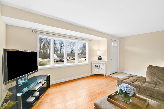 living area with baseboards and wood finished floors