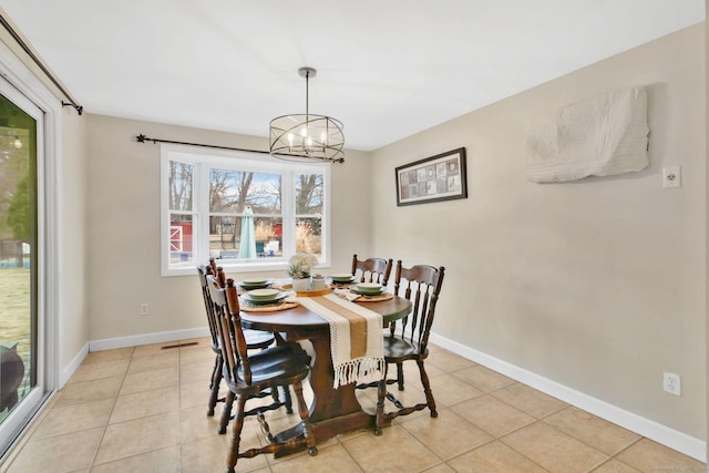 dining room featuring light tile patterned floors, baseboards, and an inviting chandelier