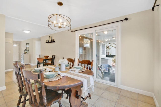 dining area featuring an inviting chandelier, light tile patterned floors, and baseboards