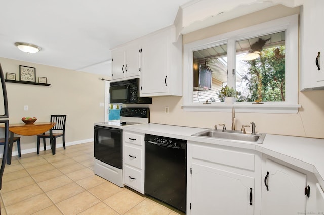 kitchen with light countertops, light tile patterned floors, white cabinets, black appliances, and a sink