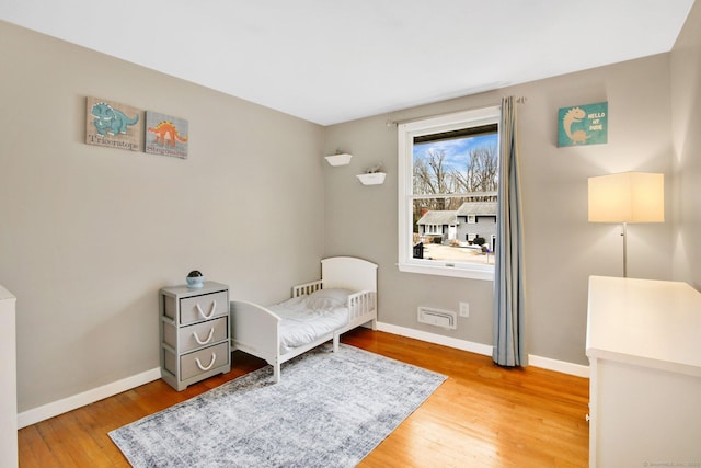 bedroom with light wood finished floors and baseboards