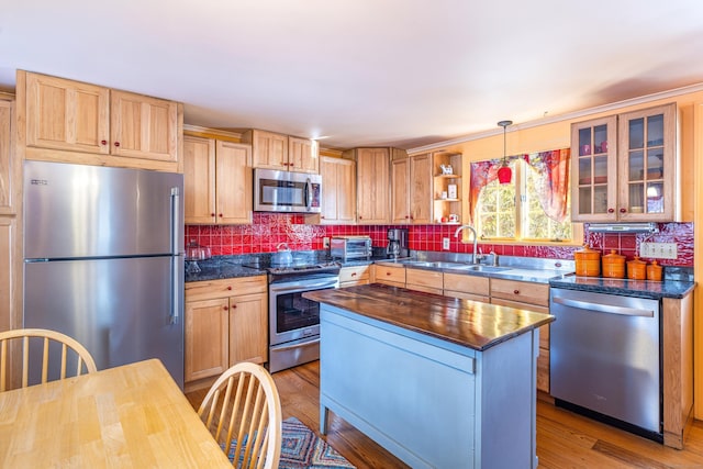 kitchen featuring a sink, appliances with stainless steel finishes, tasteful backsplash, and butcher block counters