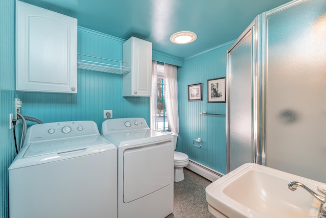 washroom with laundry area, crown molding, a baseboard radiator, washing machine and clothes dryer, and a sink