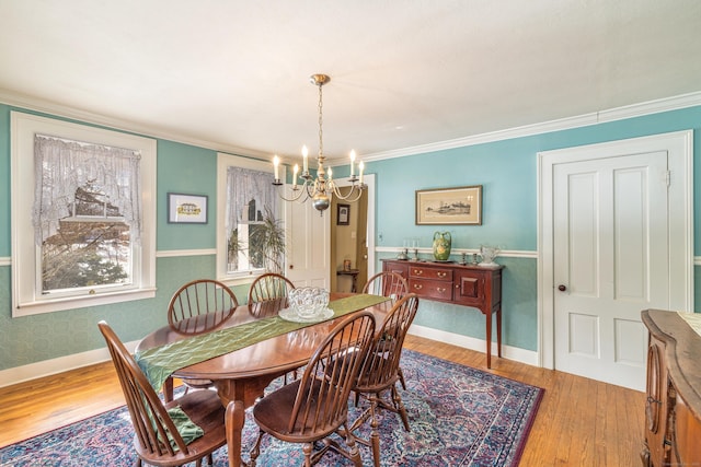 dining area featuring light wood-type flooring, baseboards, crown molding, and a chandelier