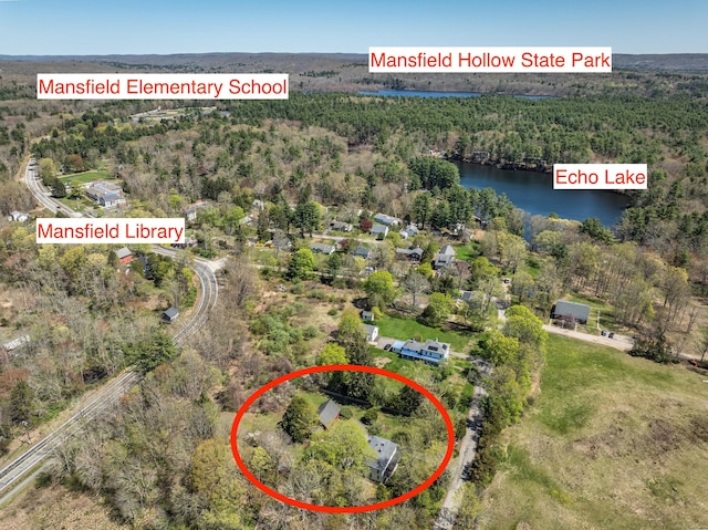 birds eye view of property featuring a water view and a wooded view