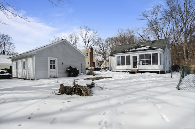 snow covered house with entry steps and fence