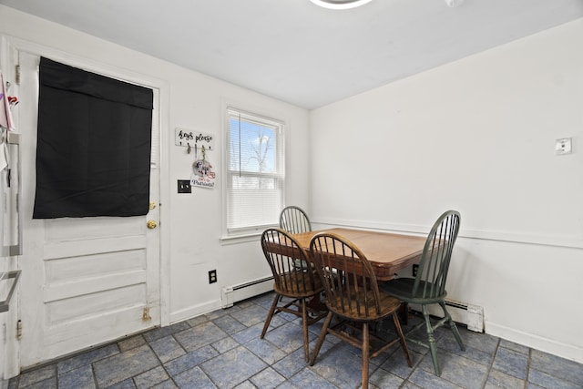 dining space featuring baseboards, a baseboard heating unit, and stone tile flooring