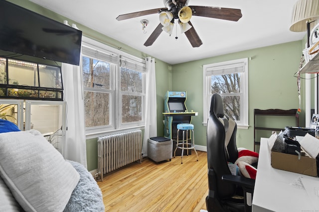 office with a ceiling fan, radiator, baseboards, and wood finished floors