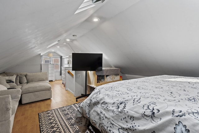 bedroom with light wood-type flooring and lofted ceiling with skylight