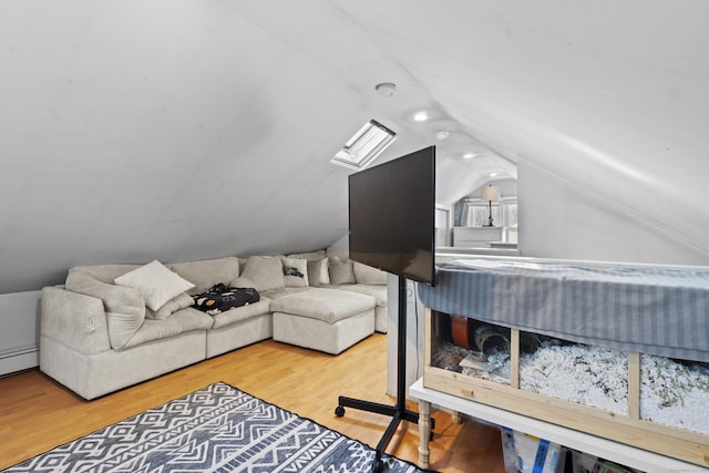 living area with a baseboard heating unit, lofted ceiling, and wood finished floors