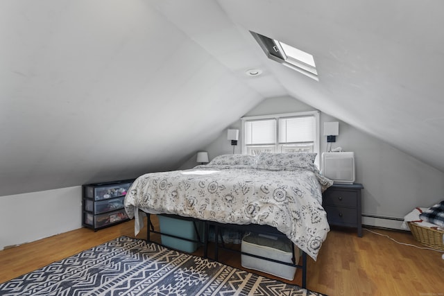 bedroom with lofted ceiling, a baseboard heating unit, and wood finished floors