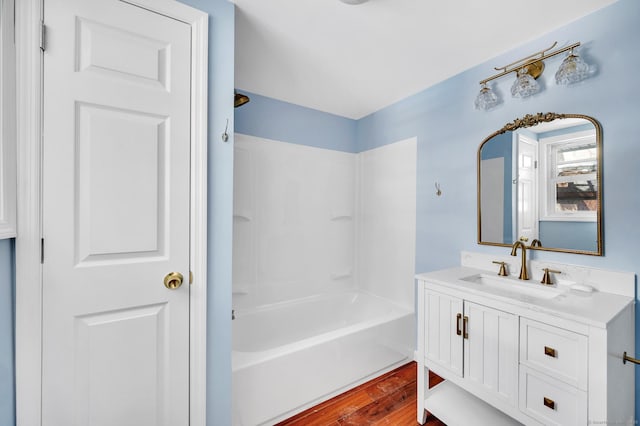 bathroom with vanity, wood finished floors, and shower / bath combination