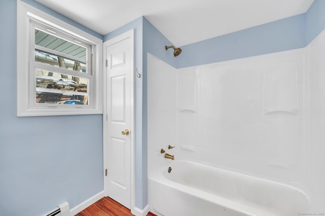 bathroom with wood finished floors, shower / bathtub combination, baseboards, and a baseboard radiator