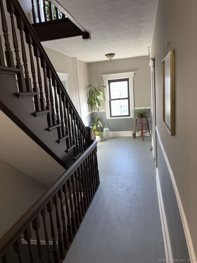 interior space with baseboards and stairway