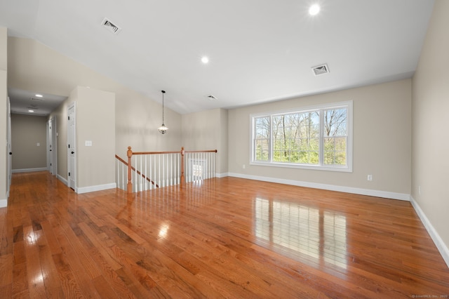 spare room with hardwood / wood-style floors, recessed lighting, baseboards, and visible vents