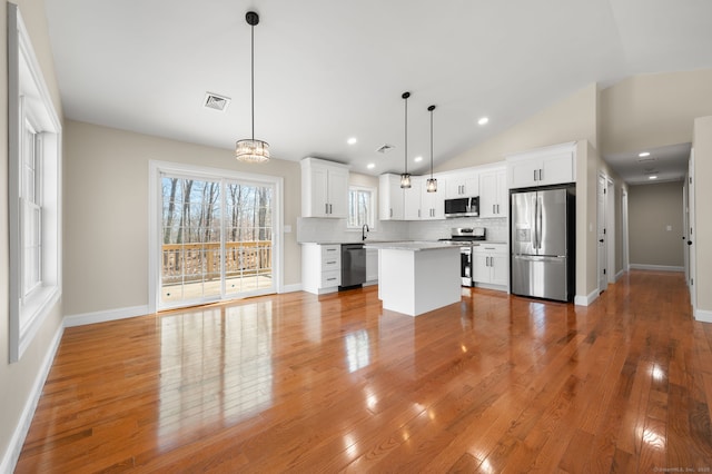 kitchen with visible vents, appliances with stainless steel finishes, light wood-style flooring, and decorative backsplash