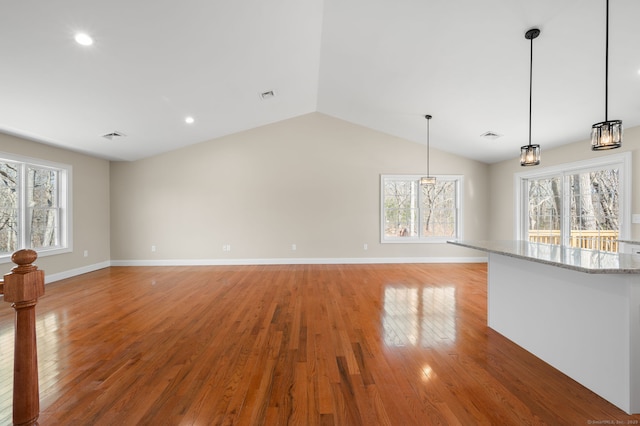 unfurnished living room featuring visible vents, baseboards, lofted ceiling, and light wood-style floors