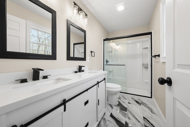 full bathroom featuring marble finish floor, a stall shower, toilet, and a sink