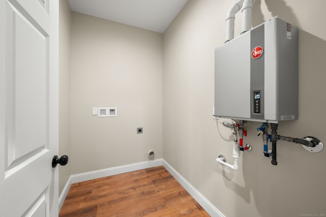 laundry area featuring baseboards, water heater, hookup for a washing machine, wood finished floors, and hookup for an electric dryer