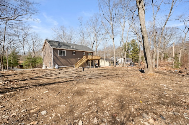 back of house featuring stairs and a deck