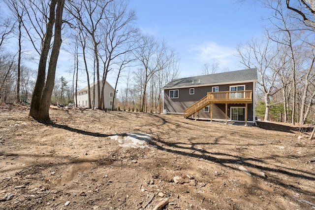 back of house featuring stairs, an outbuilding, and a wooden deck