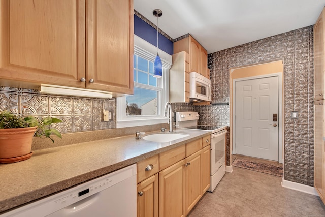 kitchen with pendant lighting, light countertops, light brown cabinetry, a sink, and white appliances